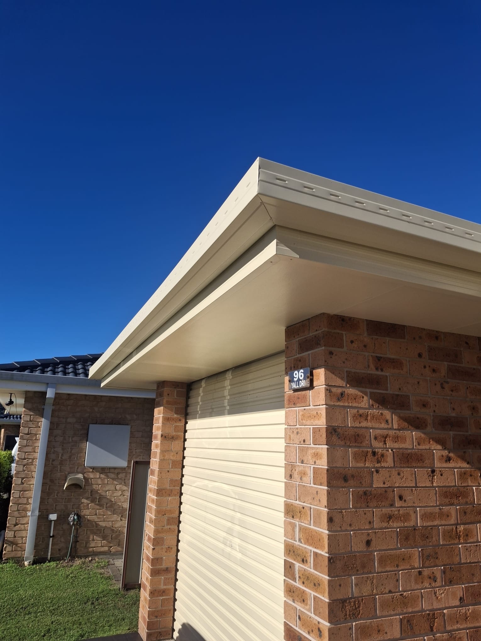Freshly painted eaves and gutters — brick home exterior after painting